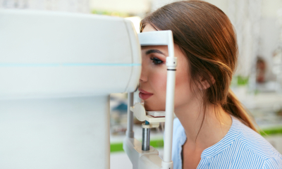 Mulher se submetendo a um exame ocular atravs do equipamento OCT